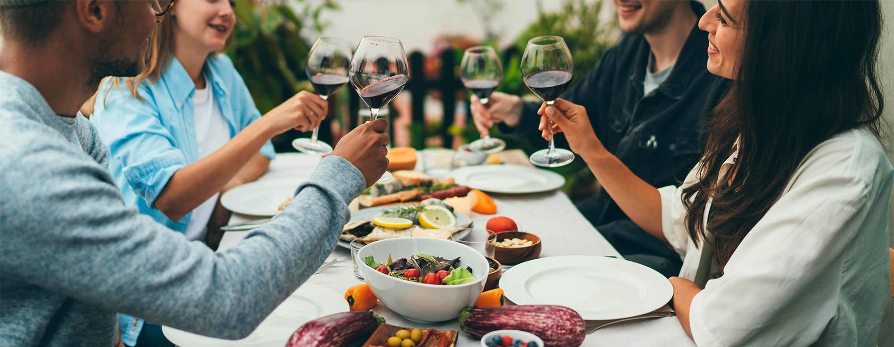 a group of people having a meal around an outdoor table